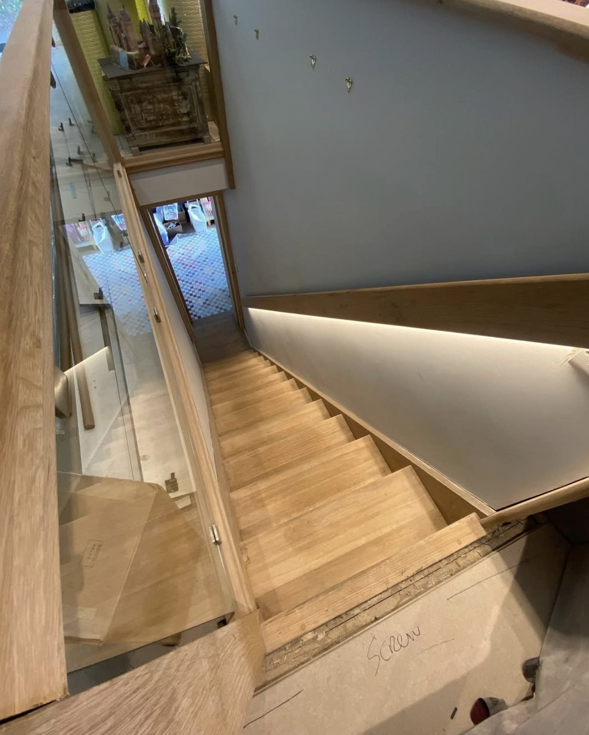 LED strip lighting concealed beneath a timber stair handrail